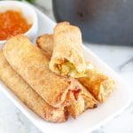 Plate of egg rolls with one that has bite taken out.