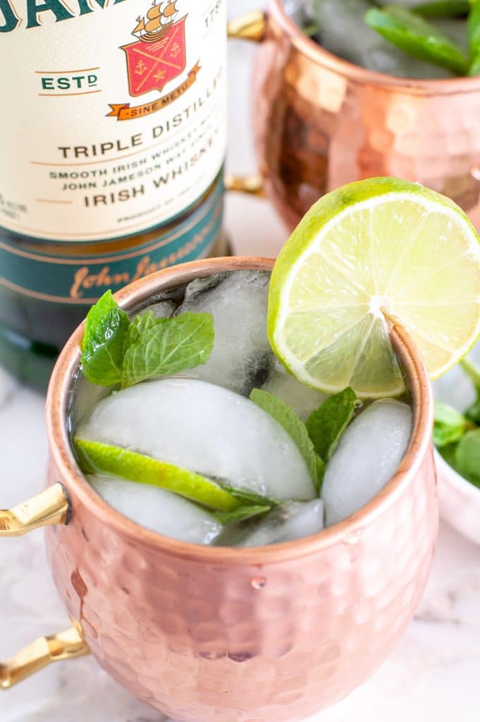 Cup with lime wedge and bottle.