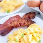 Eggs and bacon on plate.