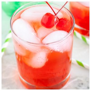 Glass of cherry soda and cherries.