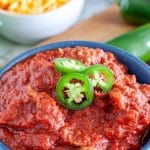 Bowl of chili with jalapeno slices.