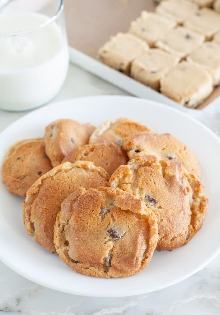 Plate of cookies with cookie dough in background.