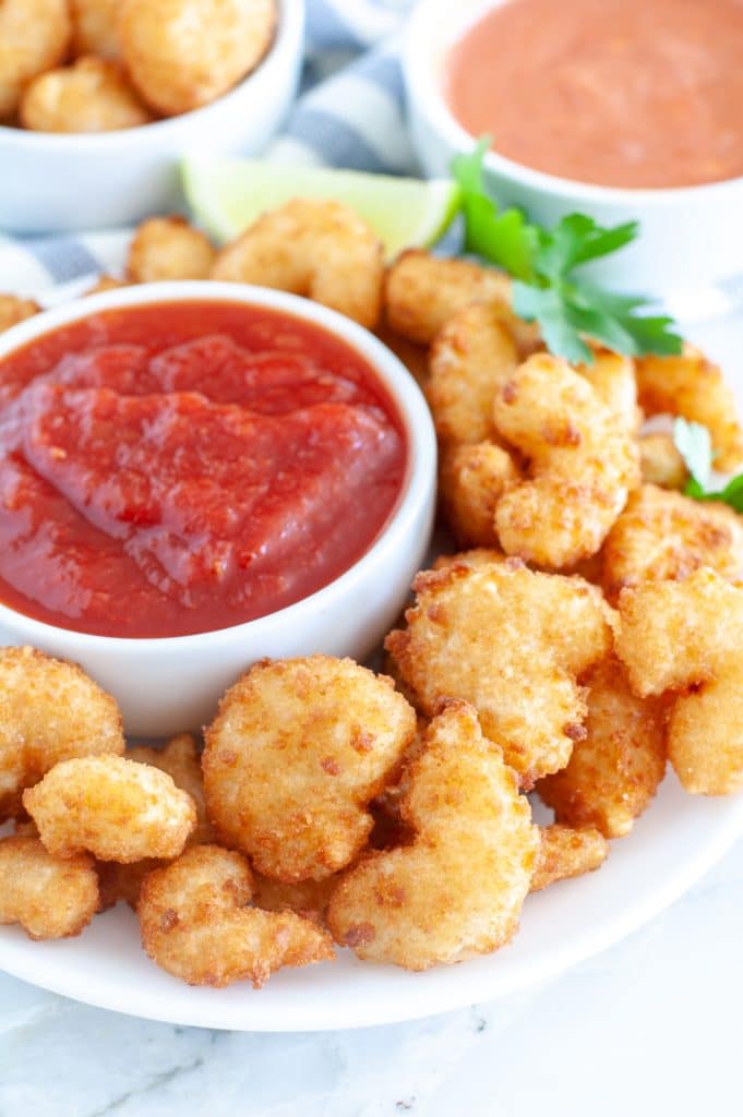 Fried shrimp on plate with cocktail sauce. 