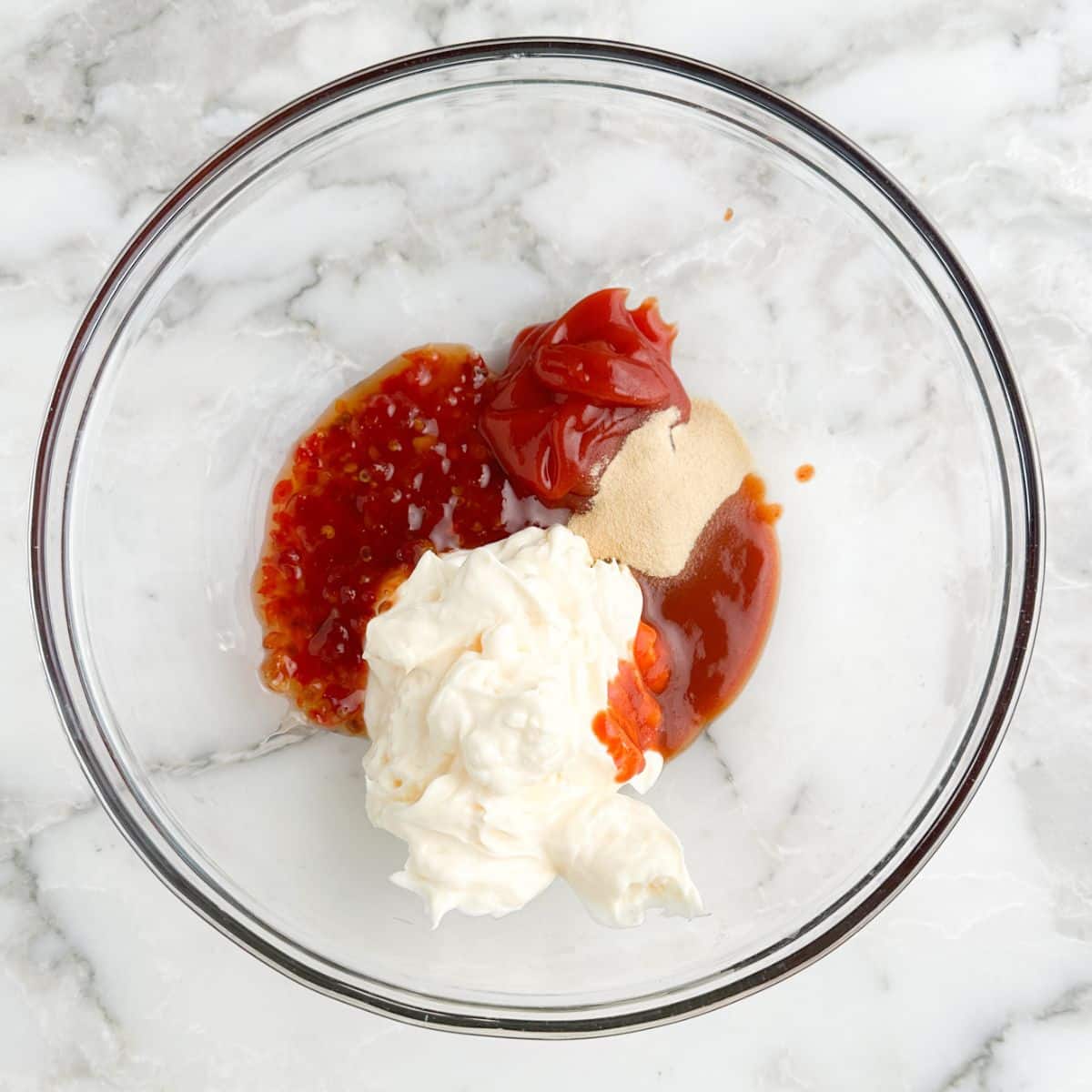Bowl of mayonnaise, ketchup, sweet chili sauce, and garlic powder.