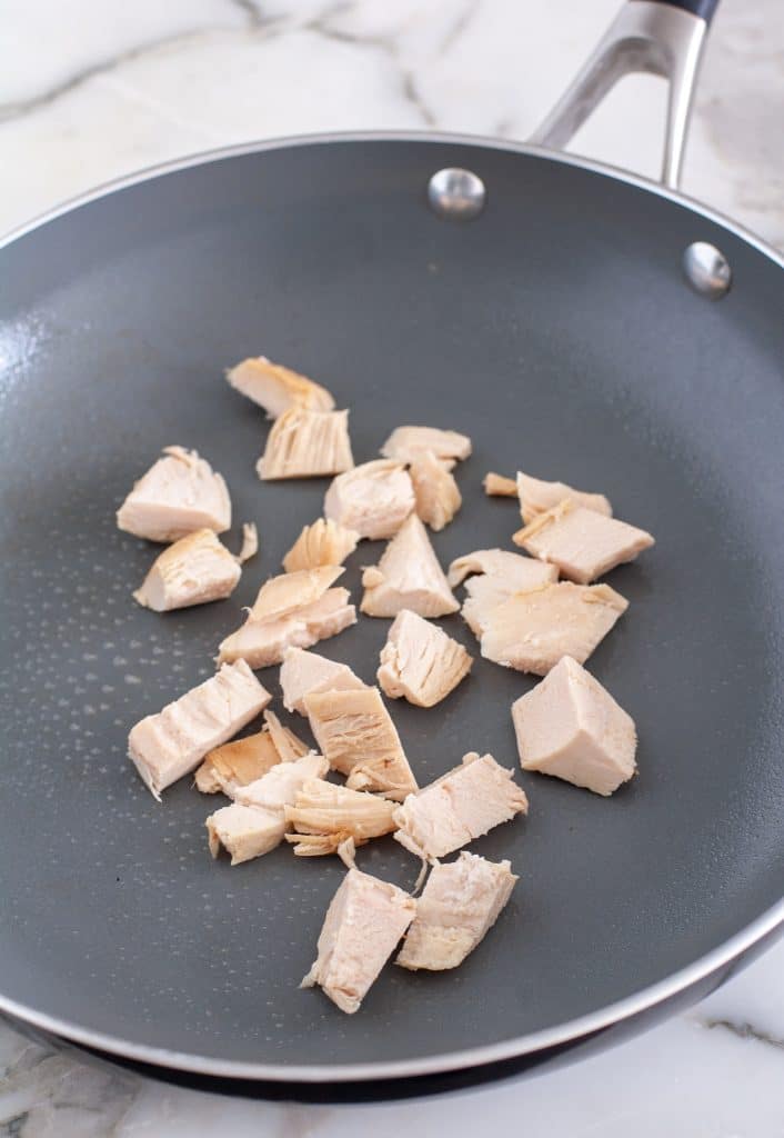 Pieces of chicken in skillet.