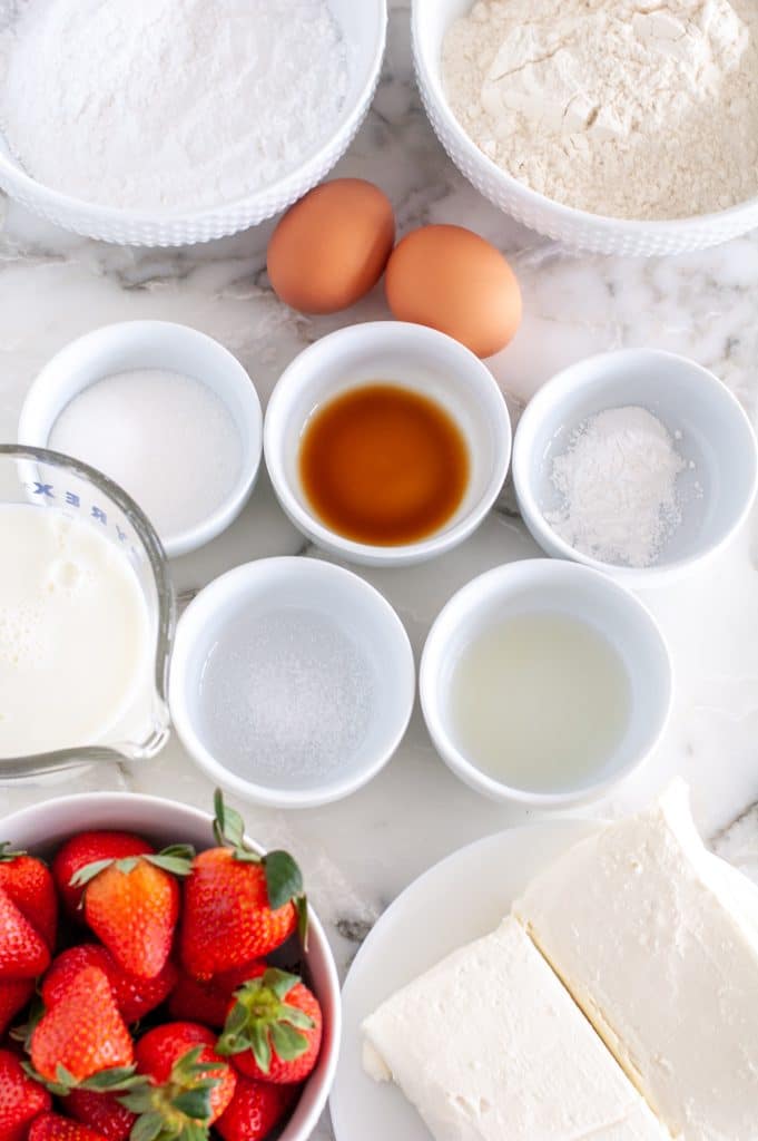 Bowl of strawberries, cream cheese, eggs, milk, sugar. 