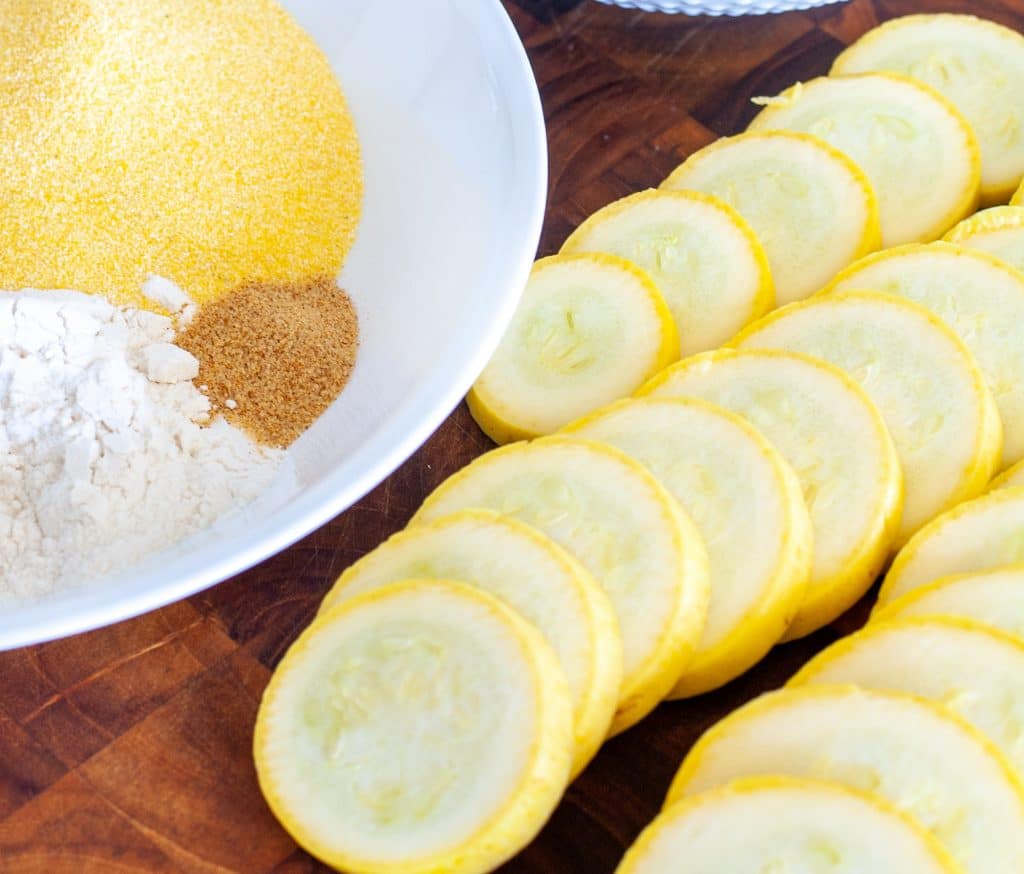 Sliced yellow squash on cutting board. 