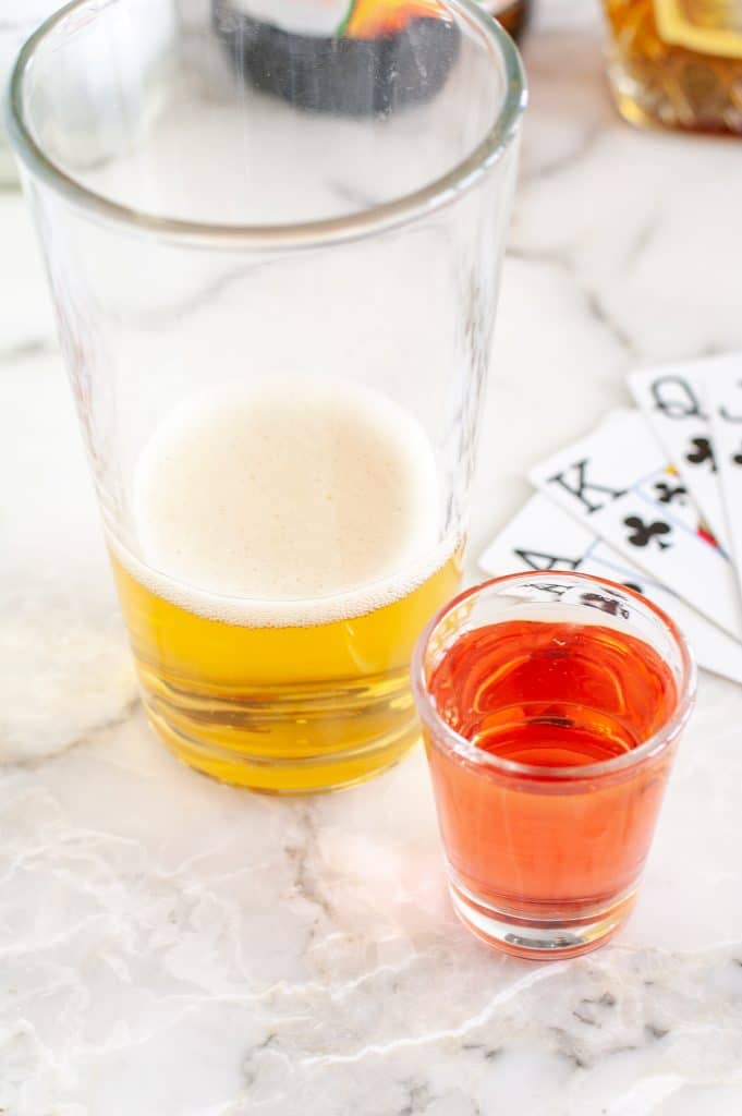 Large glass with energy drink and shot glass with liquer. 