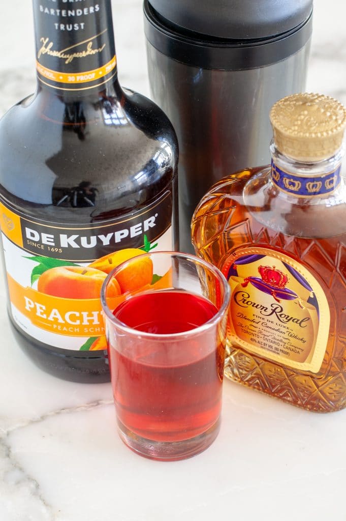 Bottle of peach schnapps, Crown Royal and cranberry juice.