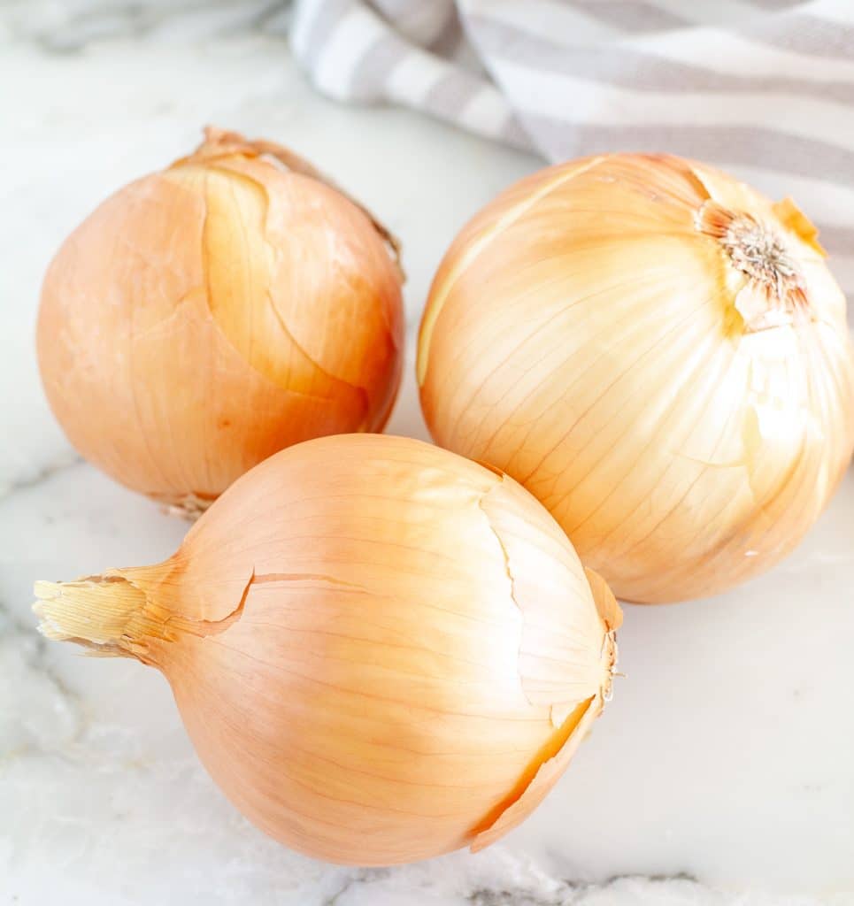 Three onions on a table.