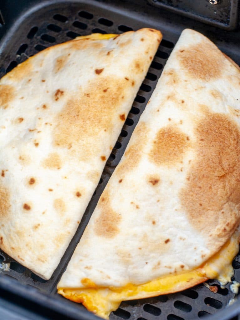 Cooked quesadilla in air fryer basket. 