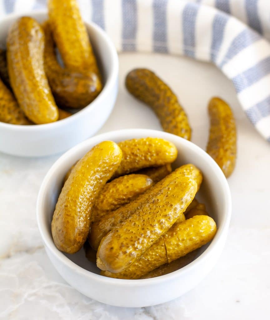 Two bowls of gherkin pickles. 