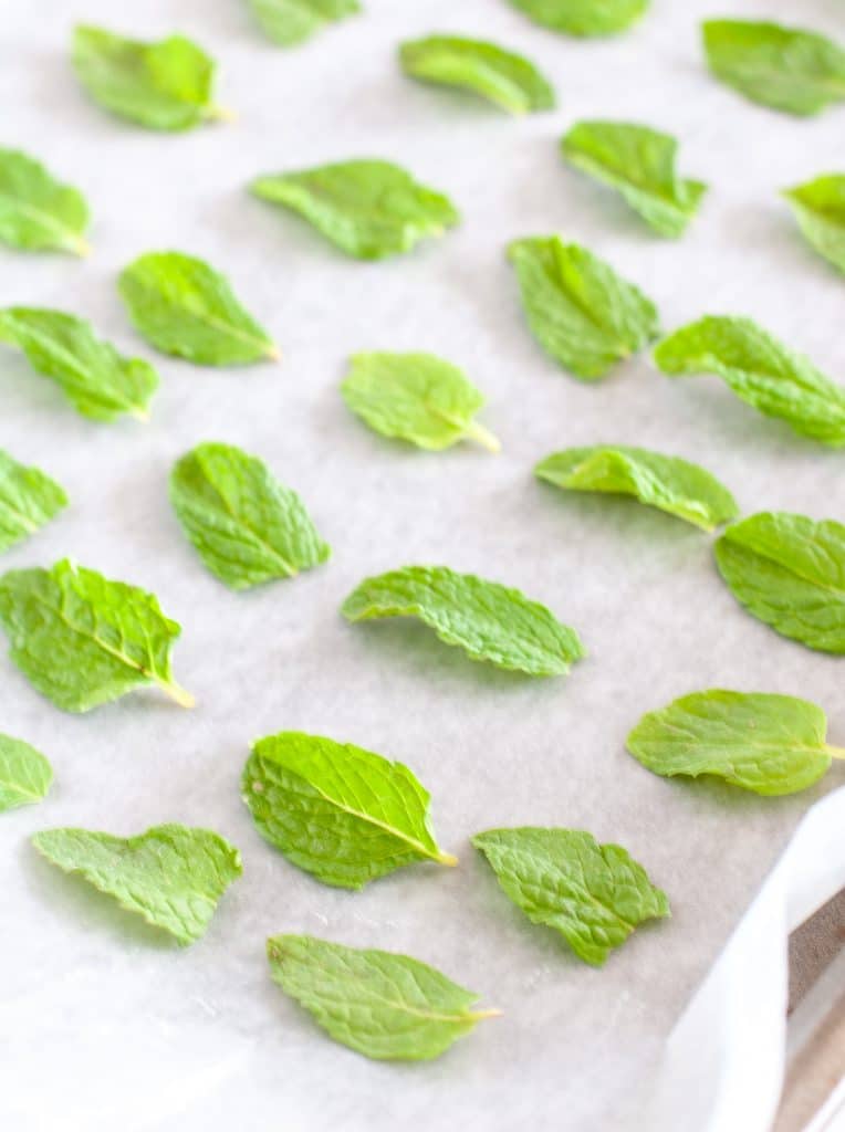 Mint leaves on parchment on a baking sheet. 