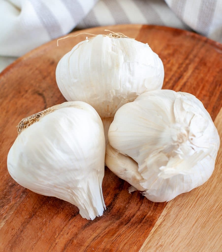 Three heads of garlic on plate. 