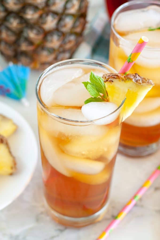 Glass of tea with mint and plate of pineapple. 