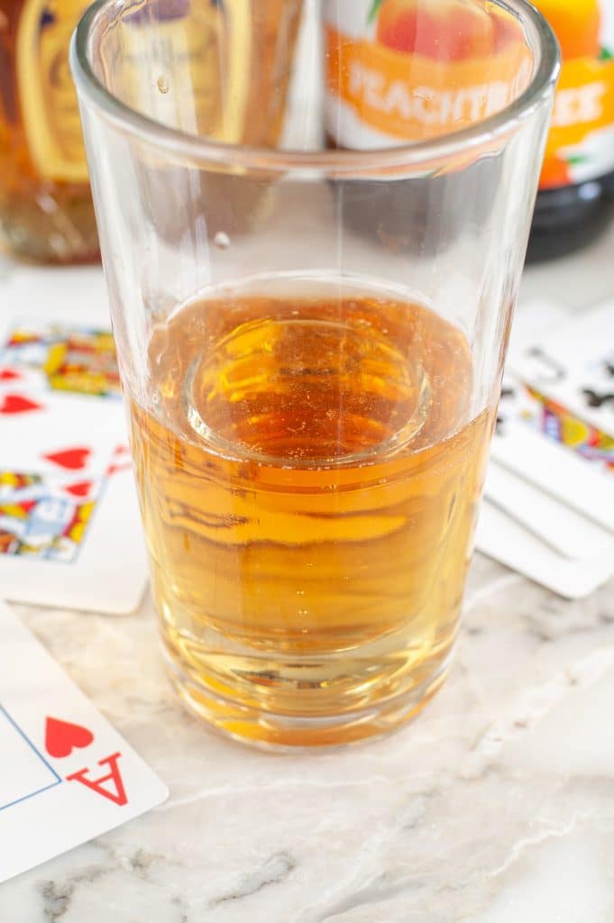 Glass with energy drinks and playing cards beside the glass. 