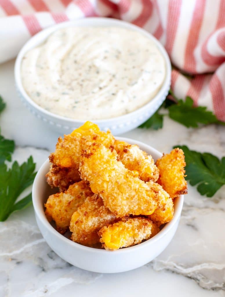 Bowl with crispy cheese curds and bowl of ranch. 