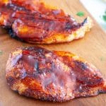 Cooked chicken breast on cutting board.