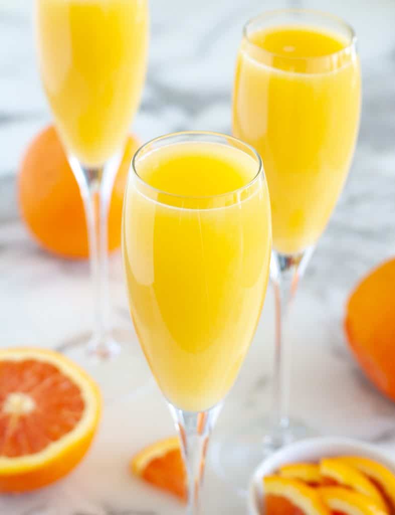 Glasses with orange juice and oranges. 