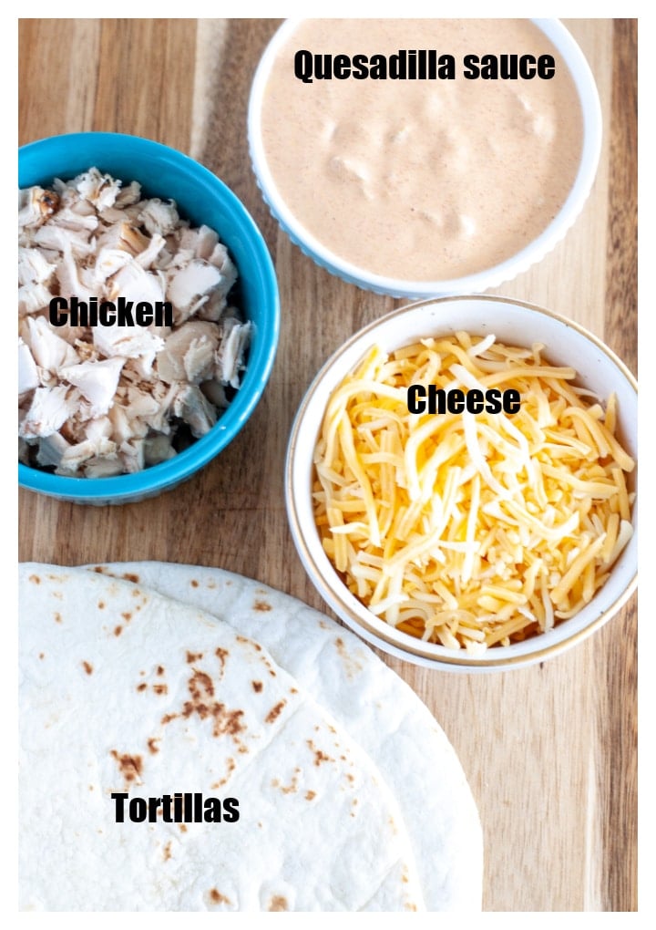 Tortillas, bowl of chicken, cheese and sauce. 