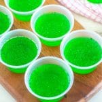 Board with cups of green jello.