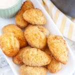 Jalapeno poppers on a plate with bowl of ranch.