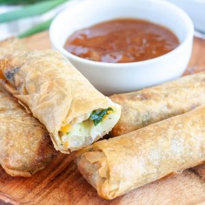 Plate of spring rolls stacked.