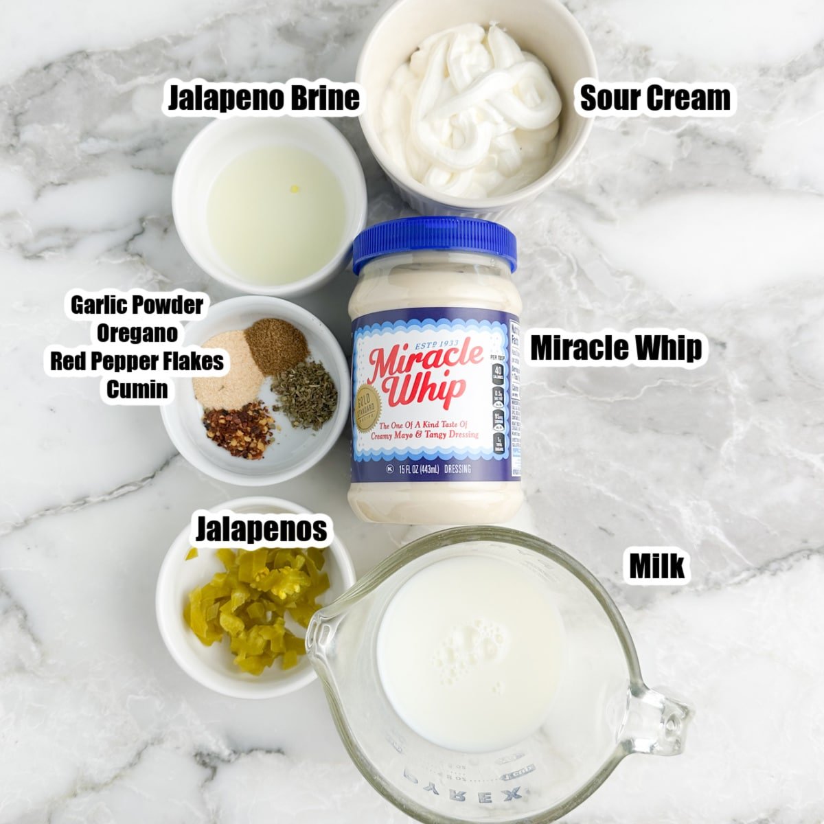 Bowl of sour cream, miracle whip, milk, seasonings, and jalapenos.