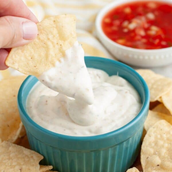 Bowl of white sauce, bowl of salsa, and tortilla chips.