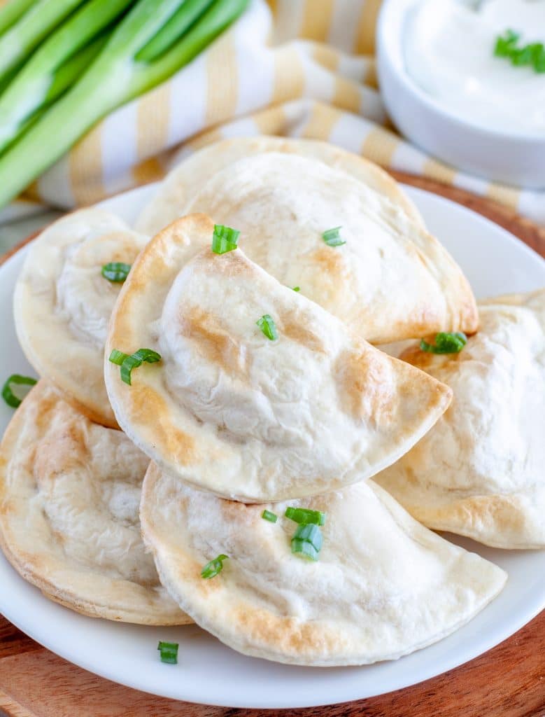 Plate of pierogies with green onion. 