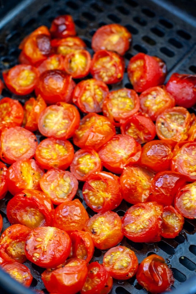 Cherry tomatoes in air fryer basket. 