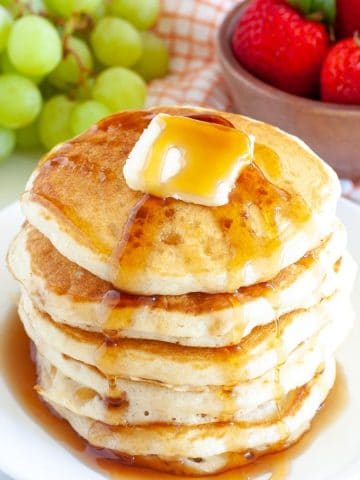 Stack of pancakes with butter and syrup.