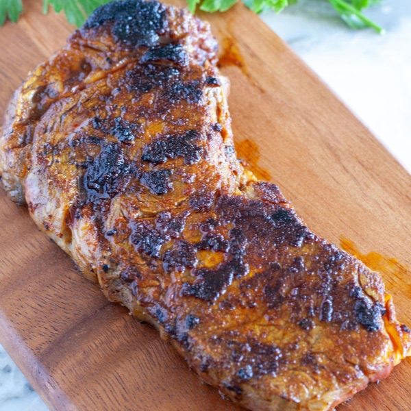 Seasoned steak on a cutting board.