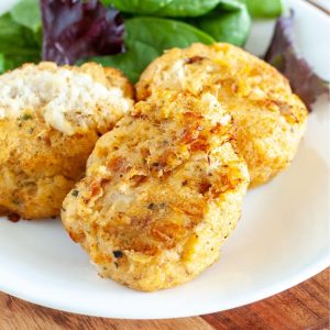 Crab cakes on a plate with lettuce.