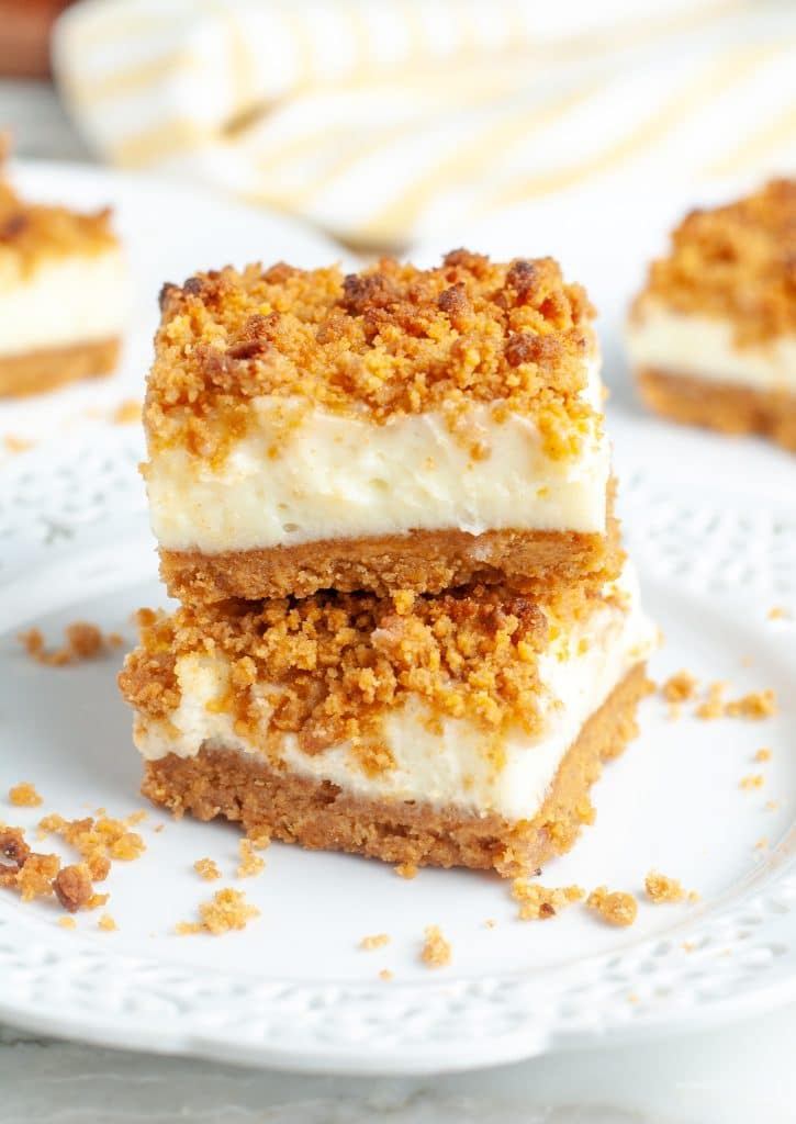 Two cheesecake bars stacked on plate. 