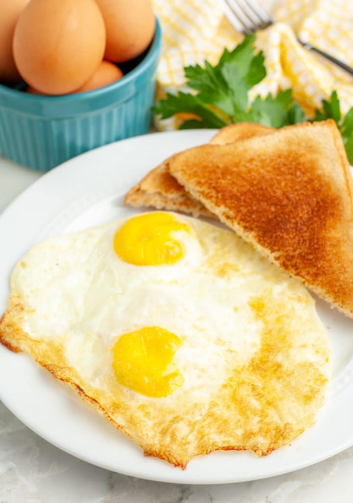 Two fried eggs on a plate.