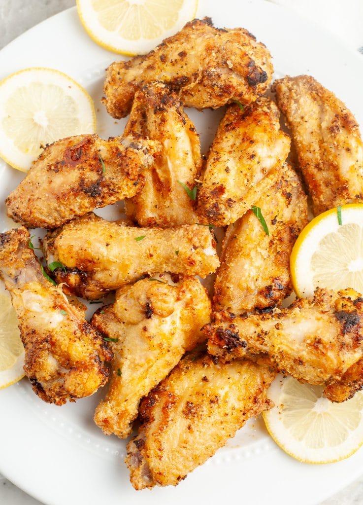Chicken wings with lemon slices on a plate. 