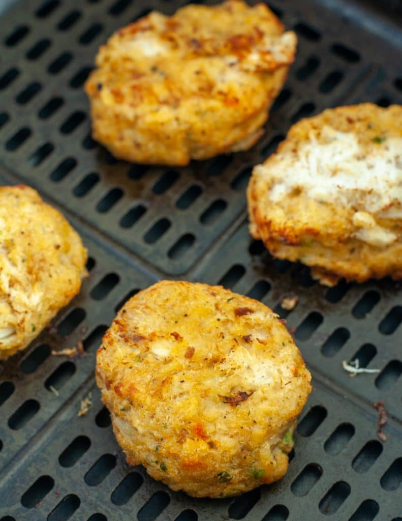 Cooked crab cakes in air fryer basket. 