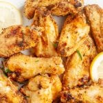 Chicken wings and lemon on a plate.