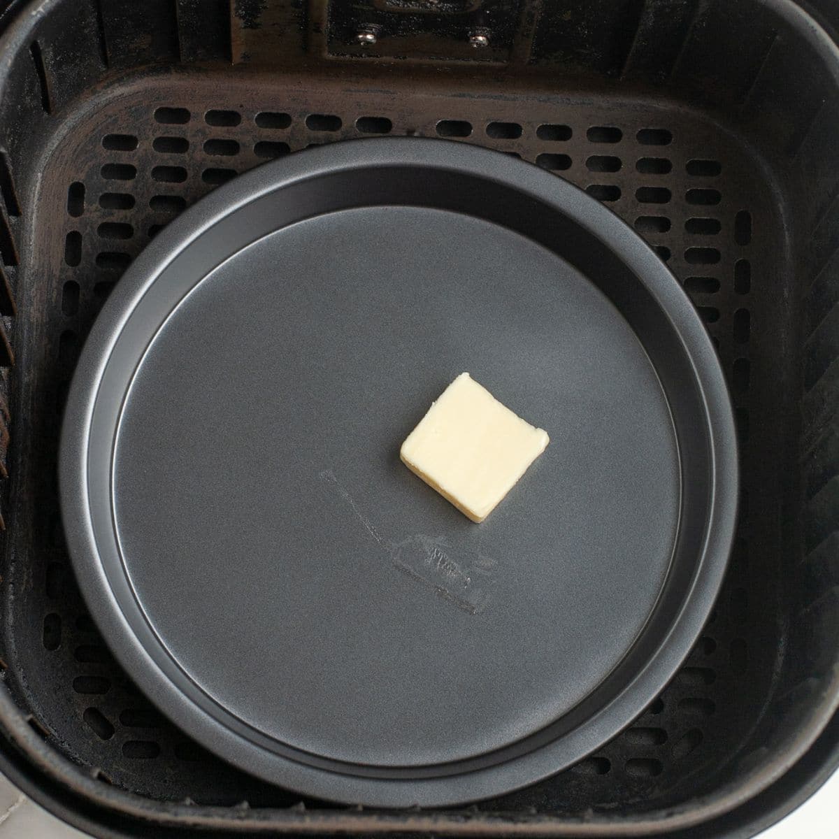Pa with butter in an air fryer basket.