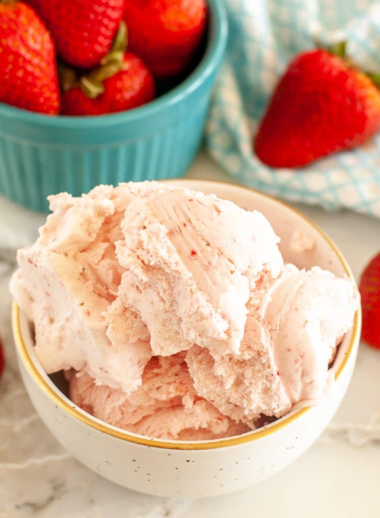 Bowl of ice cream and bowl of strawberries. 
