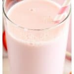 Glass of milk with pink straw.