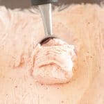 Ice cream scoop in strawberry ice cream.