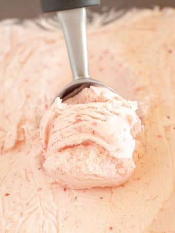 Ice cream scoop in strawberry ice cream.