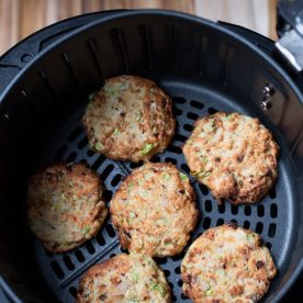 Tuna patties in air fryer basket.