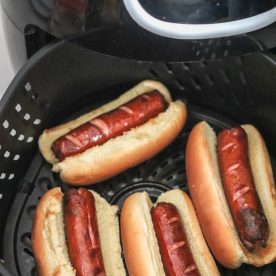 Hot dogs in air fryer basket.