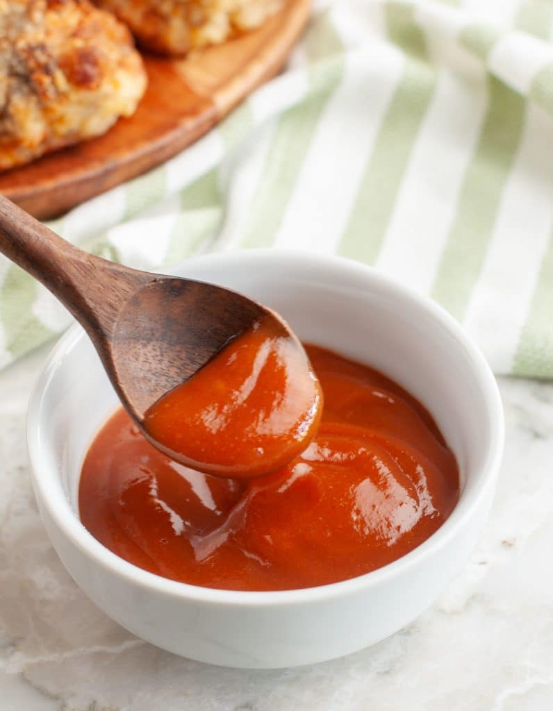 Red sauce in a bowl with wooden spoon.