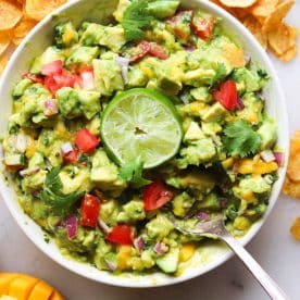 Bowl of guacamole topped with a lime.