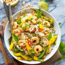 Bowl of salad with shrimp and mango.