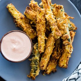 Zucchini fries on plate with sauce.